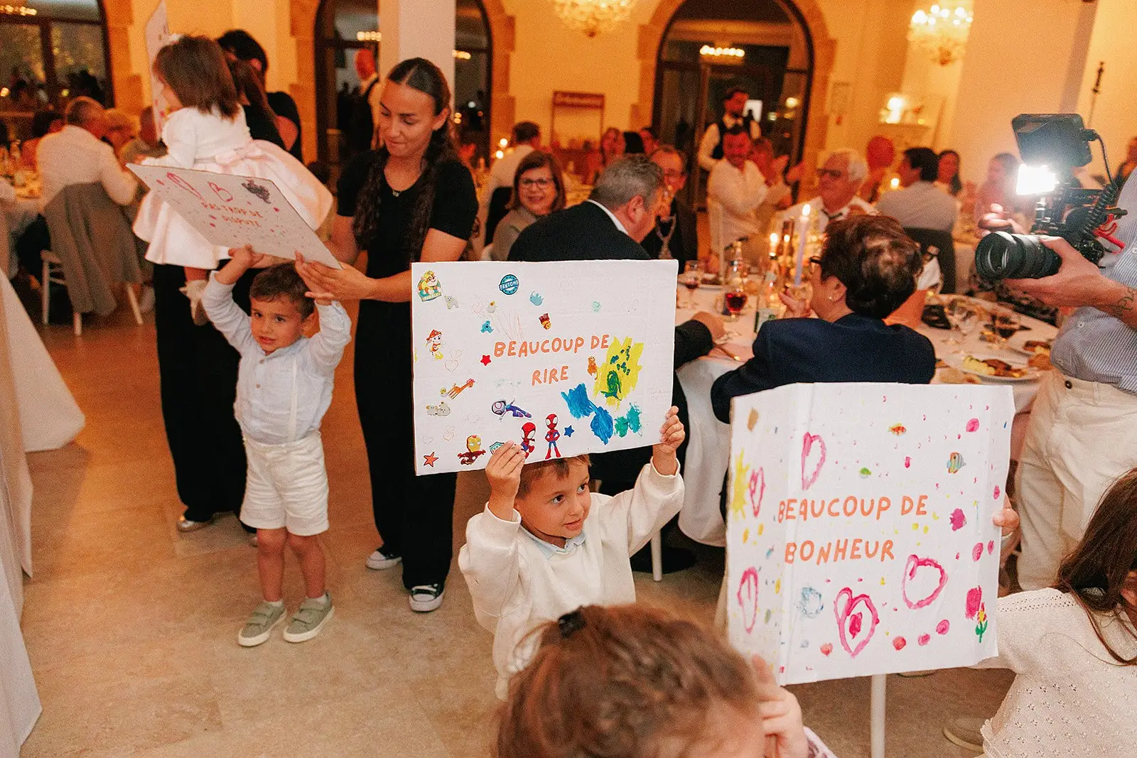 Les enfants et les animatrices présentent leurs pancartes pendant une réception