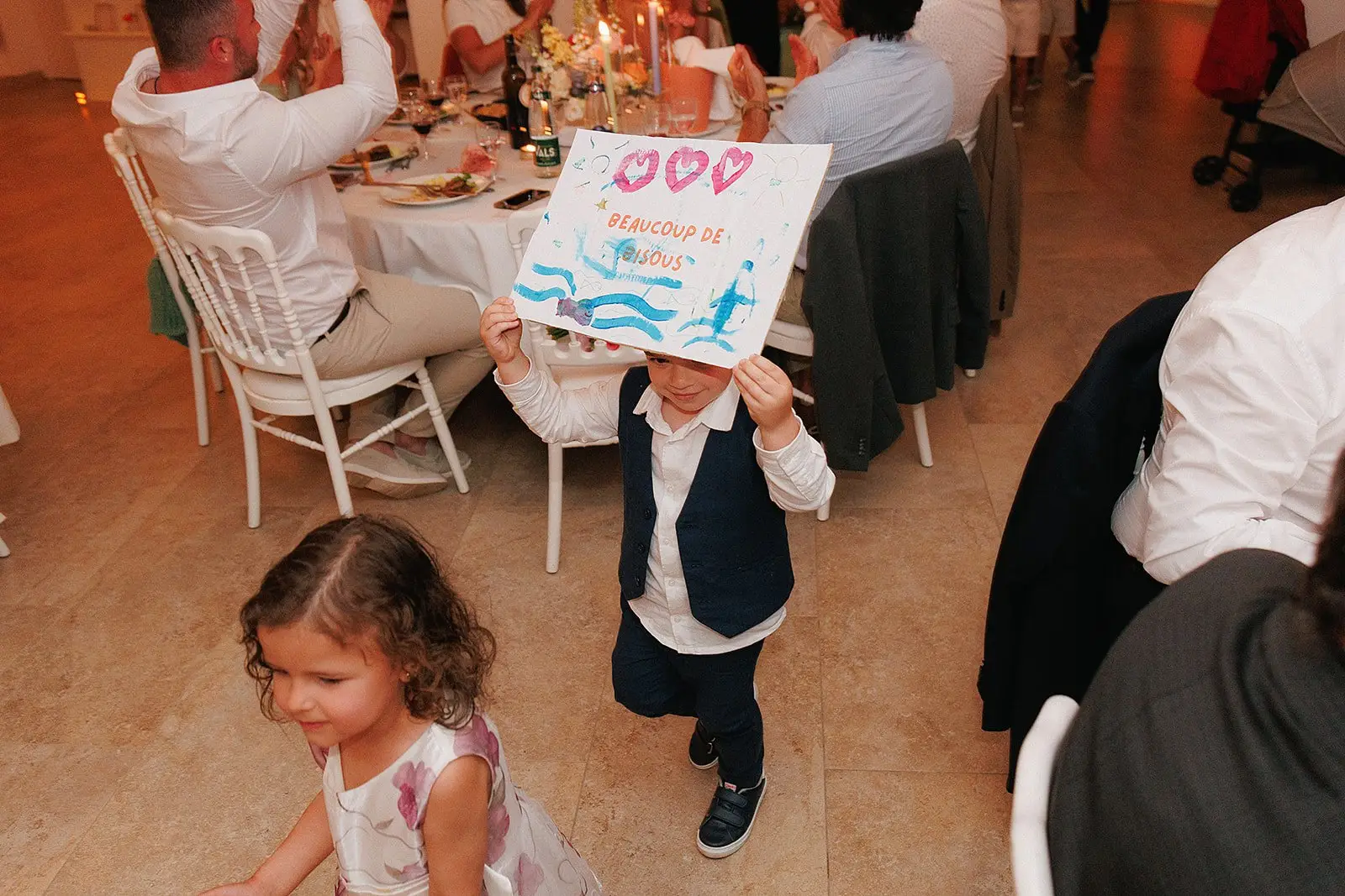 Un enfant tient sa pancarte décorée pendant une réception