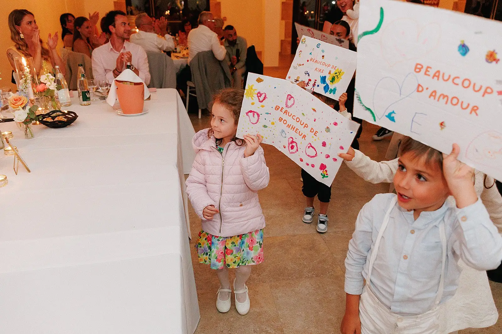 Des enfants montrent leurs messages colorés accompagnés de leur animatrice