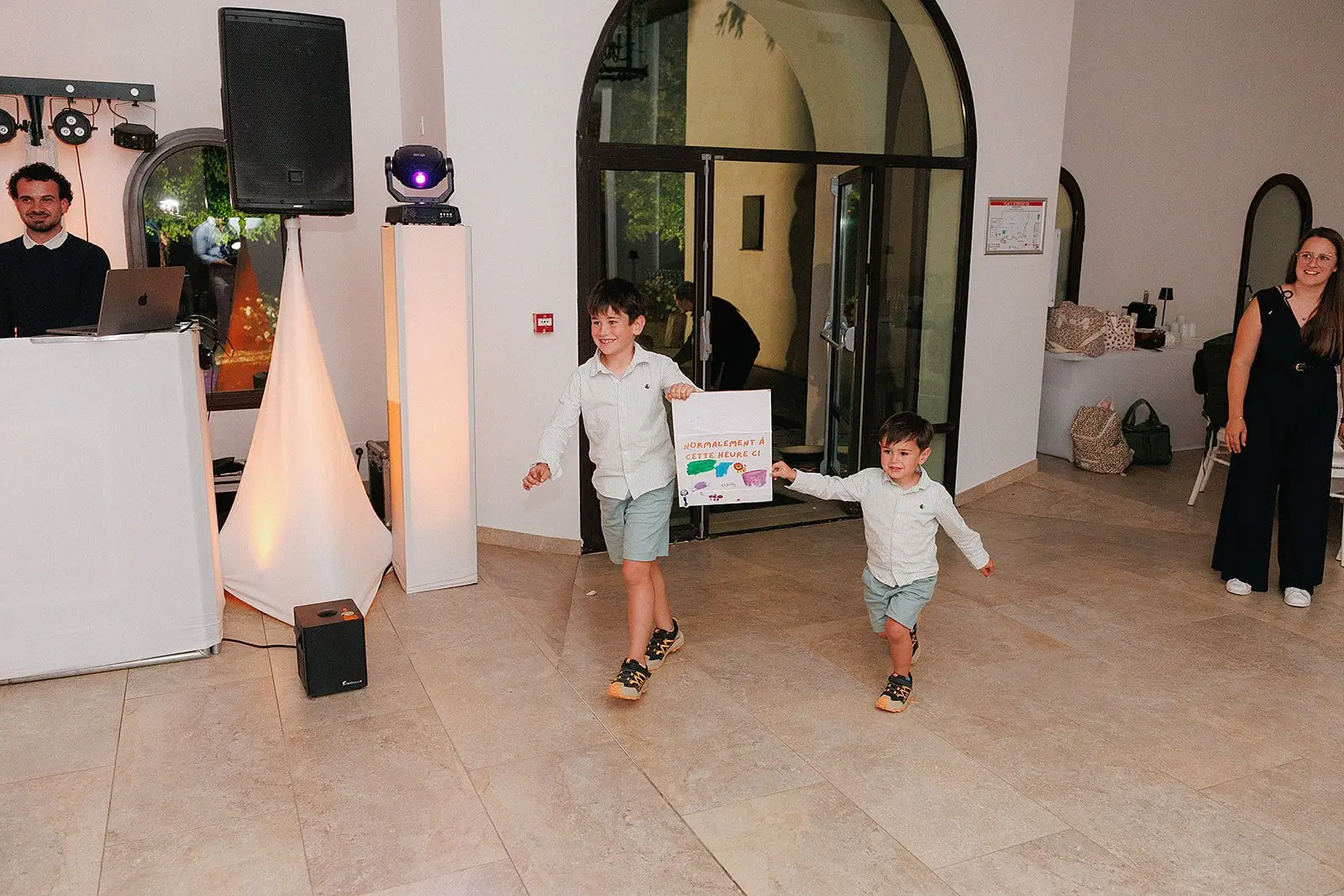 Deux garçons participent à une animation devant les invités