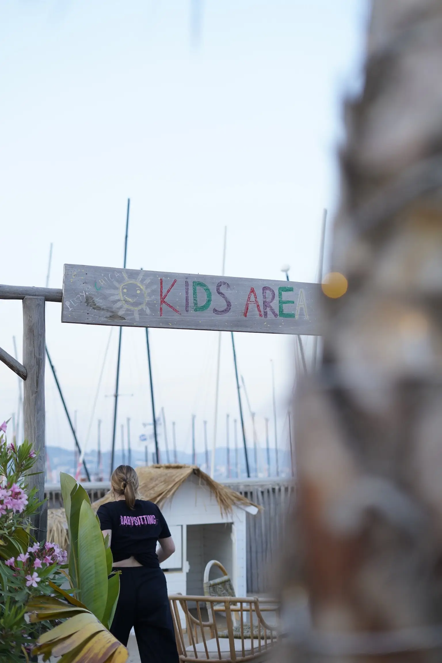 Une animatrice installe un espace signalé « Kids area » près de la plage