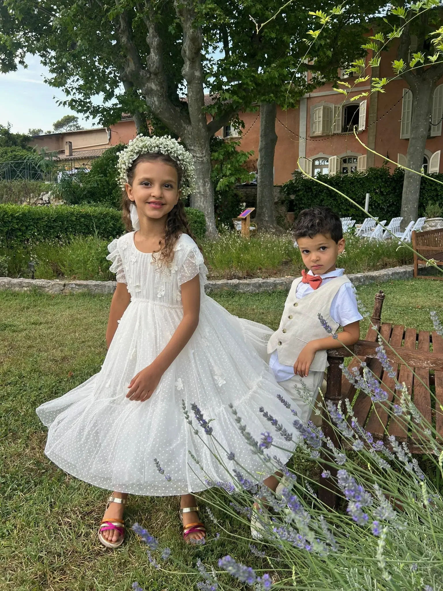 Deux enfants en tenue de cérémonie dans un jardin