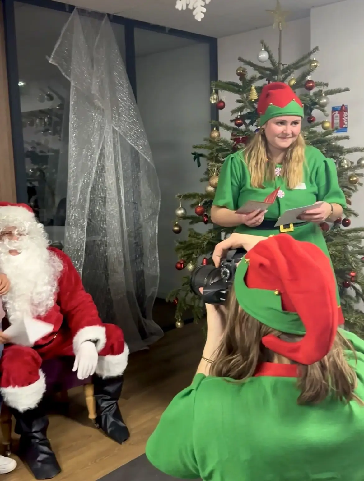 Une animatrice distribue les cadeaux aux enfants avec le Père Noël