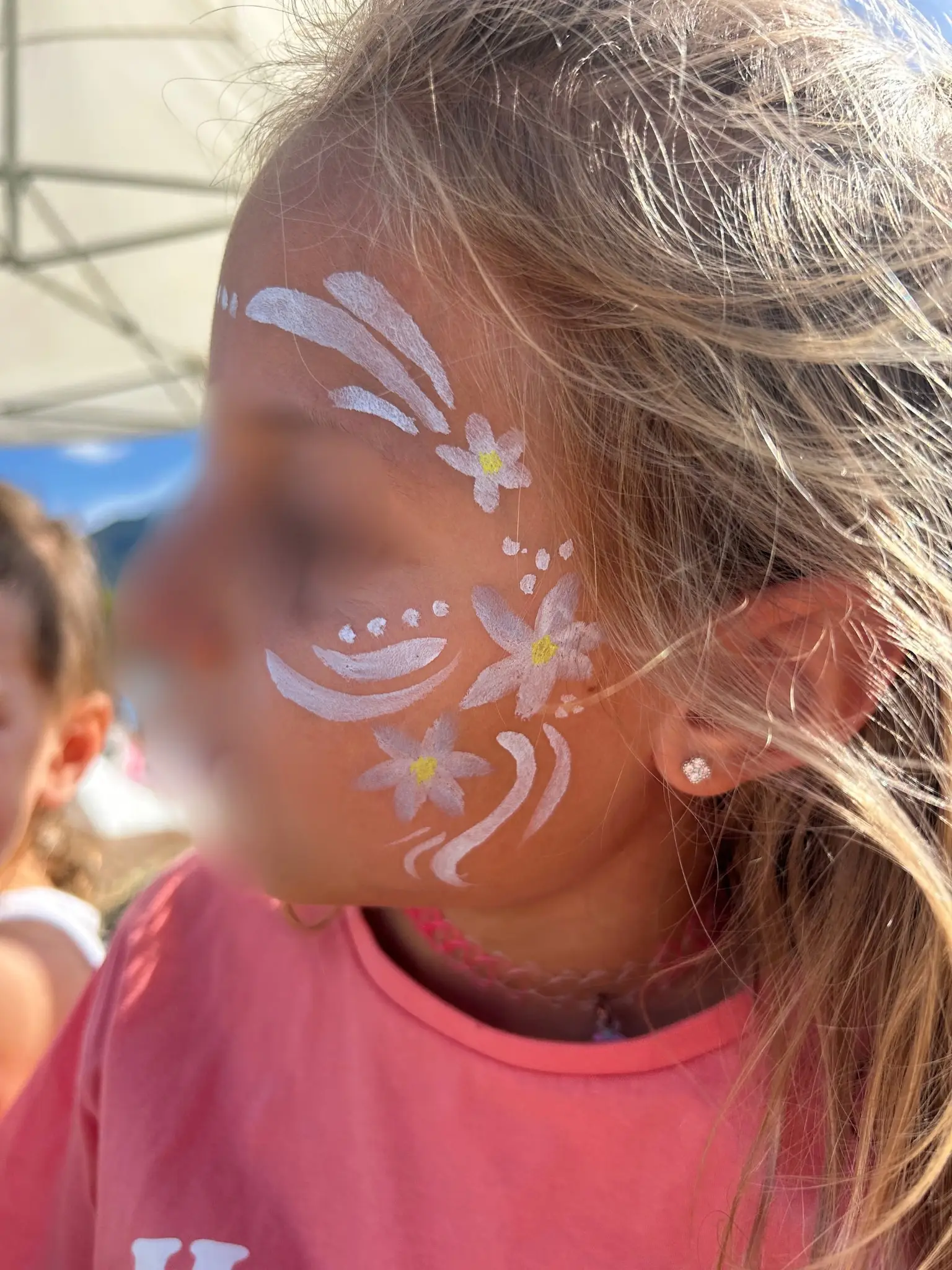 Une fillette maquillée de fleurs et de paillettes