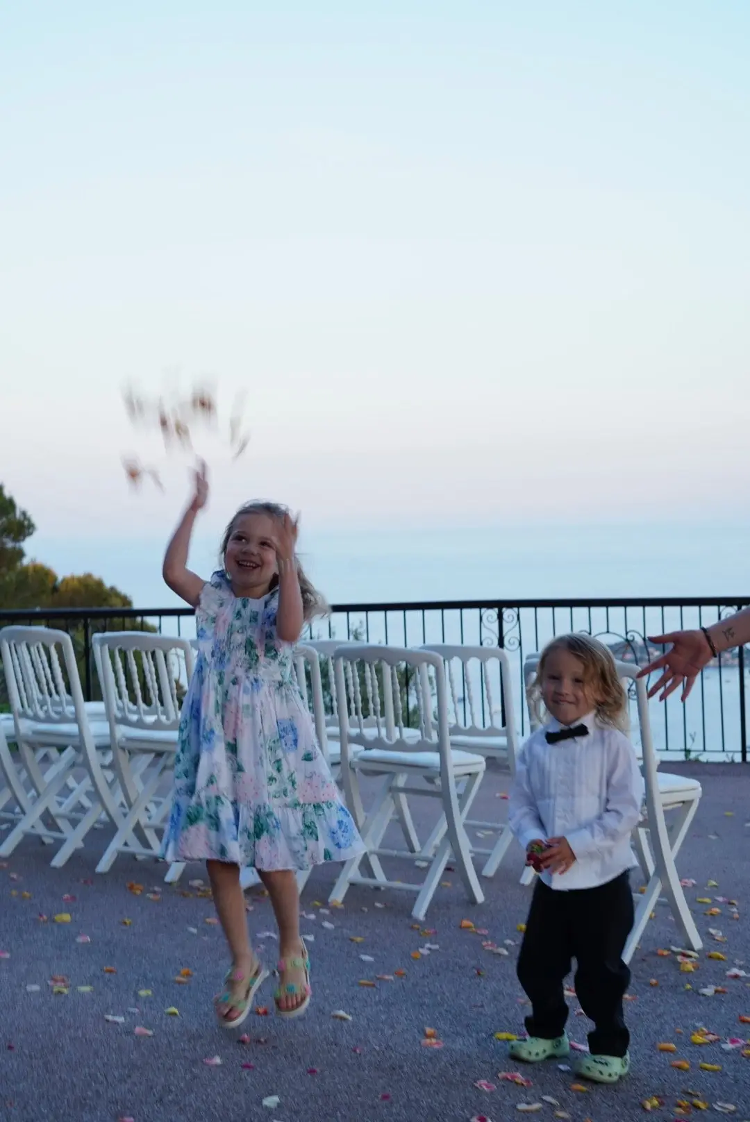 Une petite fille lance des pétales devant les chaises de la cérémonie