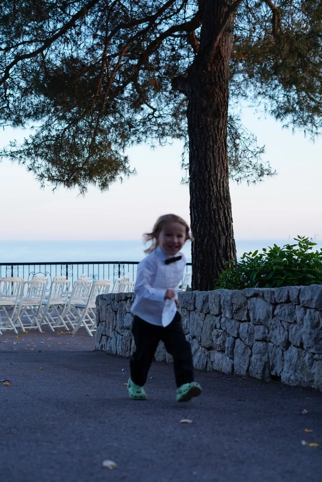 Un petit garçon court sur l’esplanade face à la mer