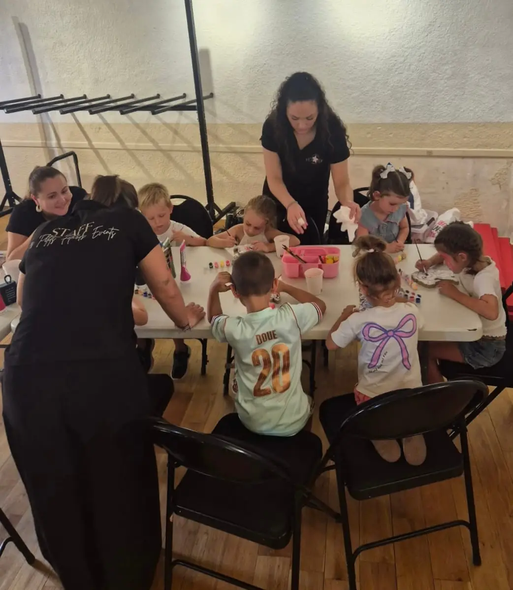 Deux animatrices encadrent un atelier créatif autour d’une grande table d’enfants
